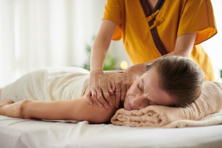 Foto de Mujer de mediana edad recibiendo relajante masaje de espalda en el salón de spa - Imagen libre de derechos