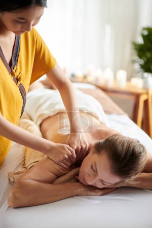 Photo for Mature woman getting shoulders and back massage with oils in spa salon - Royalty Free Image