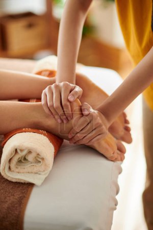 Téléchargez les photos : Masseuse massage des pieds de la cliente dans le salon de spa - en image libre de droit