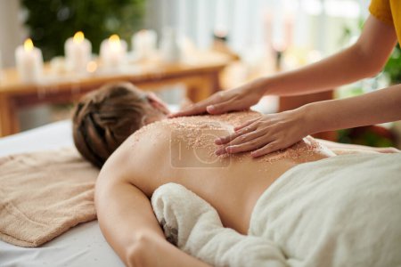 Foto de Mujer recibiendo masaje exfoliante exfoliante en el salón de spa - Imagen libre de derechos