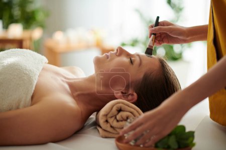 Téléchargez les photos : Femme mature obtenir procédure spa y compris masque d'argile dans le salon de beauté - en image libre de droit