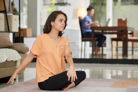 Téléchargez les photos : Young woman following video on tv screen when doing yoga at home - en image libre de droit