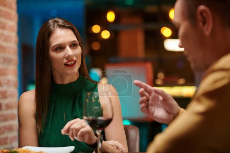 Photo for Young woman enjoing romantic date with man in fancy restaurant - Royalty Free Image