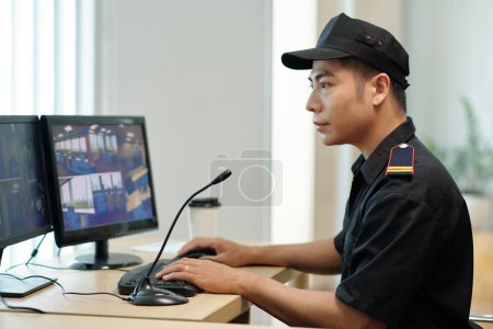 Téléchargez les photos : Security guard watching videos on computer screen - en image libre de droit