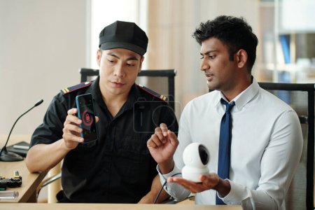Téléchargez les photos : Security guards testing new application for surveillance camera - en image libre de droit