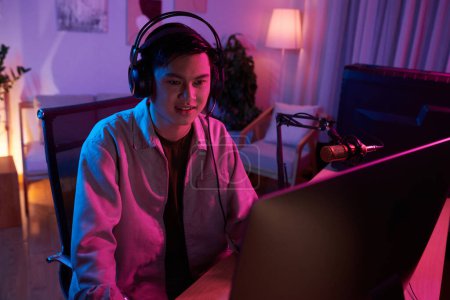 Téléchargez les photos : Joueur excité jouant jeu de tir en ligne en utilisant un ordinateur puissant et clavier rgb - en image libre de droit