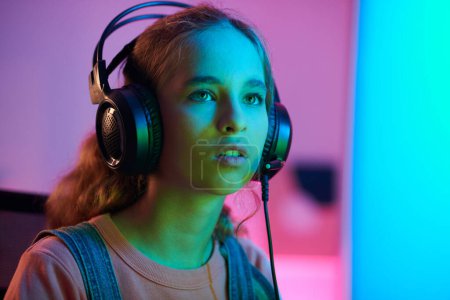 Foto de Teenage girl reading videogame tournament requirements on computer screen - Imagen libre de derechos