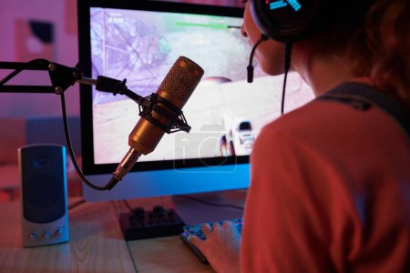Téléchargez les photos : Teenage girl streaming herself playing first person shooter - en image libre de droit