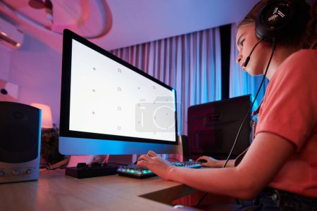 Téléchargez les photos : Adolescente portant casque lors de la lecture de jeu vidéo avec des amis sur l'ordinateur - en image libre de droit
