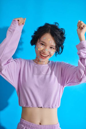 Foto de Retrato de chica alegre con pegatinas en la cara bailando - Imagen libre de derechos
