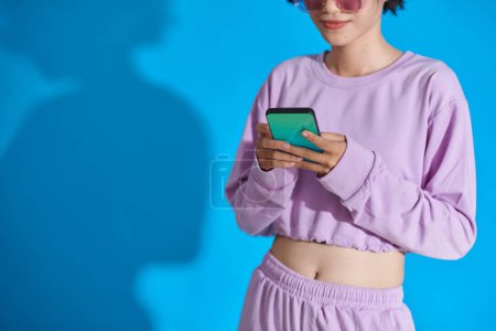 Cropped image of teenage girl checking social media on smartphone