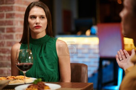 Téléchargez les photos : Portrait de femme élégante en robe verte ayant rendez-vous dans un restaurant chic - en image libre de droit