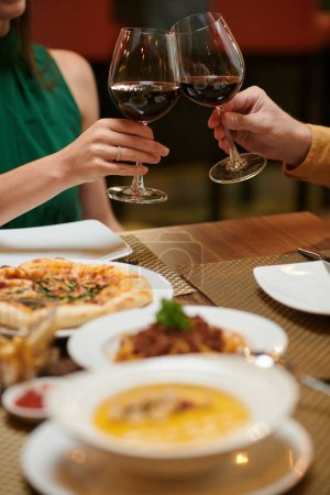 Photo for Couple enjoying romantic date in restaurant and drinking red wine - Royalty Free Image