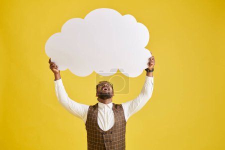 Téléchargez les photos : Heureux homme d'affaires excité tenant grand nuage de papier, isolé sur jaune - en image libre de droit