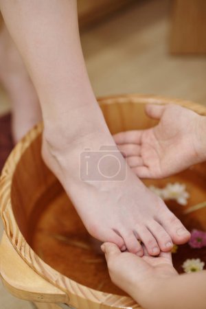 Téléchargez les photos : Travailleur de salon de spa faisant bain de pieds pour client féminin - en image libre de droit