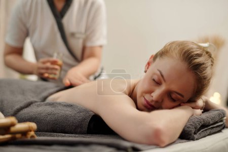 Téléchargez les photos : Young woman getting relaxing back massage in spa salon - en image libre de droit