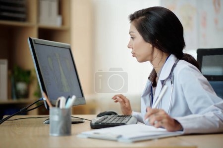 Téléchargez les photos : Docteur examinant la radiographie pulmonaire à l'écran de l'ordinateur - en image libre de droit