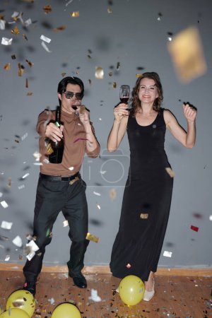 Téléchargez les photos : Joyeux homme et femme buvant du vin et s'amusant à la fête - en image libre de droit