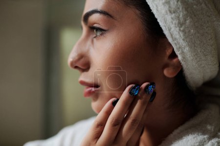 Téléchargez les photos : Image rapprochée de la femme appliquant de la crème pour le visage après avoir pris un bain - en image libre de droit