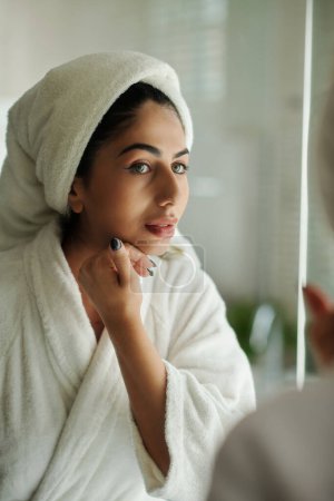 Téléchargez les photos : Jeune femme touchant sa peau lisse après avoir pris la douche du matin - en image libre de droit