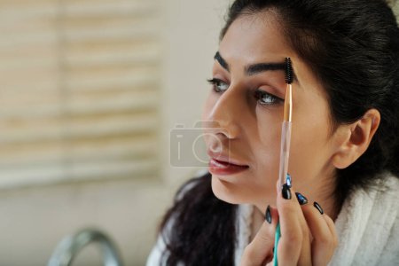 Photo for Closeup image of young woman brushing eyebrows - Royalty Free Image