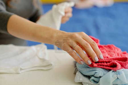 Photo for Closeup image of mother ironing clothes for her daughter - Royalty Free Image