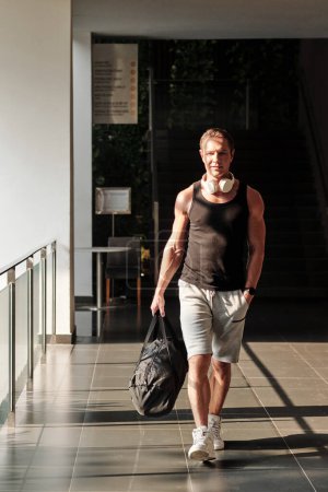 Téléchargez les photos : Homme mature actif marchant vers la salle de gym le matin - en image libre de droit