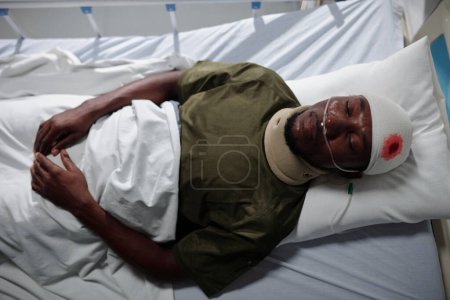 Foto de Vista de ángulo alto del soldado afroamericano acostado en la cama con herida en el hospital militar - Imagen libre de derechos
