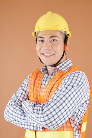 Photo for Studio portrait of smiling confident civil engineer in hardhat crossing arms and looking at camera - Royalty Free Image