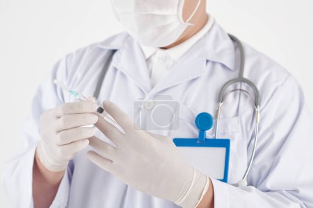 Téléchargez les photos : Mains du médecin en gants de caoutchouc tenant une seringue avec vaccin contre le coronavirus - en image libre de droit