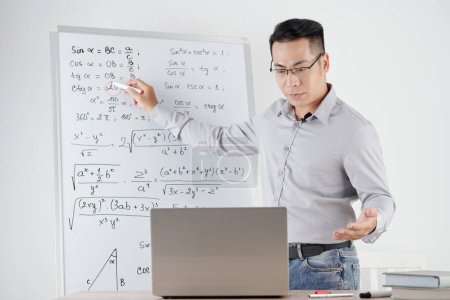 Photo for Mathematics teacher answering question of student and explaining every variable in formula - Royalty Free Image