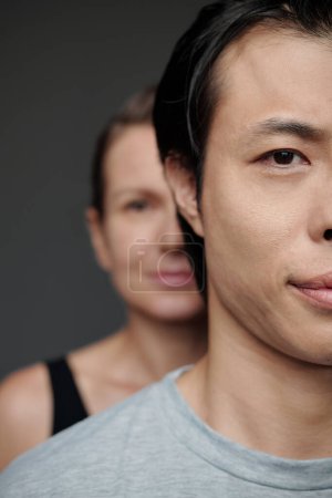 Téléchargez les photos : Demi-visage de l'homme japonais et femme mature debout derrière lui - en image libre de droit