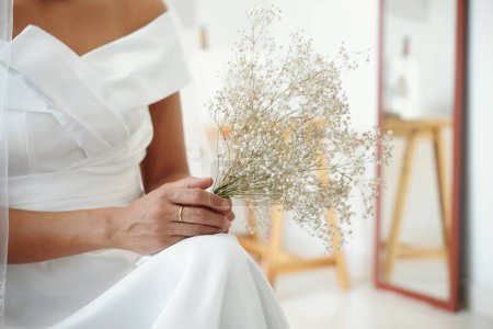 Téléchargez les photos : Petit bouquet dans les mains de la mariée en robe blanche - en image libre de droit