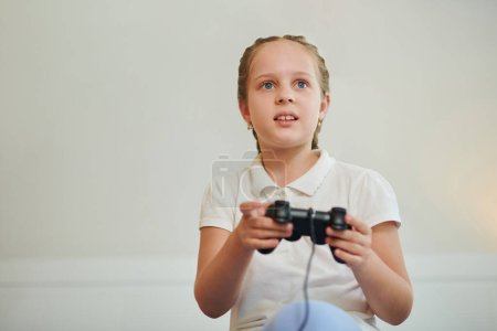 Foto de Chica alegre jugando videojuego en casa - Imagen libre de derechos