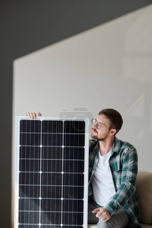 Téléchargez les photos : Jeune homme excité en chemise à carreaux regardant le panneau solaire - en image libre de droit