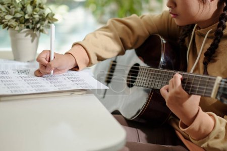Téléchargez les photos : Fille écrit des notes de musique lors de la composition de la chanson - en image libre de droit