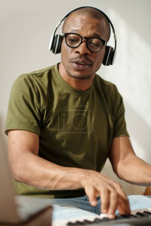 Photo for Talented musician wearing headphones when playing electronic piano - Royalty Free Image