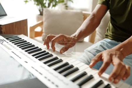 Photo for Creative young man playing electronic piano at home - Royalty Free Image