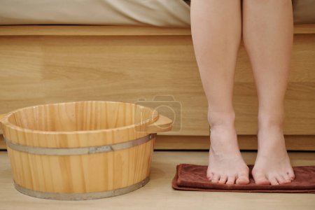 Téléchargez les photos : Pieds de jeune femme à côté d'un bassin en bois dans un salon de spa - en image libre de droit