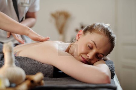 Foto de Mujer joven recibiendo masaje de espalda con aceites en el salón de spa - Imagen libre de derechos