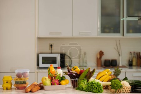 Photo for Kitchen counter with various fresh groceries, fruits and vegetables - Royalty Free Image