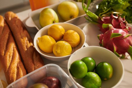 Foto de Cuencos con limas frescas, limón y maracuyá en la mesa de la cocina - Imagen libre de derechos