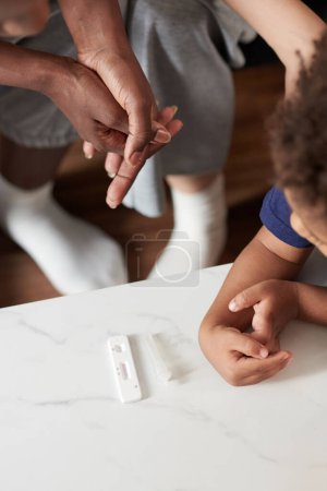 Téléchargez les photos : Mère et enfant en attente d'un test rapide du coronavirus casette montrer le résultat - en image libre de droit