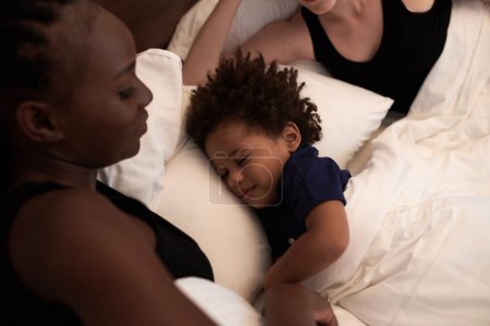 Téléchargez les photos : Calme heureux petit garçon dormant dans le lit de ses parents, co-sommeil et l'heure du lit concept de routine - en image libre de droit