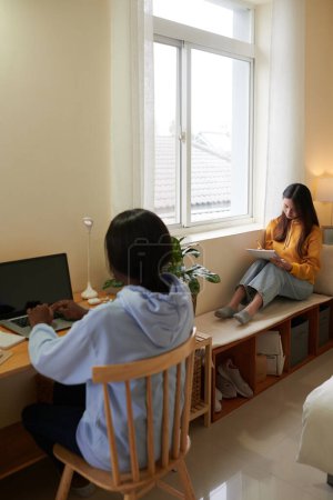 Foto de Chicas universitarias serias enfocadas estudiando en el dormitorio para los próximos exámenes - Imagen libre de derechos