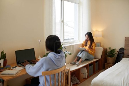 Foto de Estudiantes universitarias serias estudiando en el dormitorio - Imagen libre de derechos