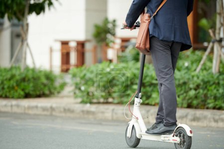 Photo for Cropped image of entrepreneur or student riding to work on electric kick scooter - Royalty Free Image