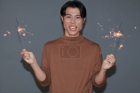 Foto de Retrato de hombre alegre excitado quemando luces de bengala - Imagen libre de derechos
