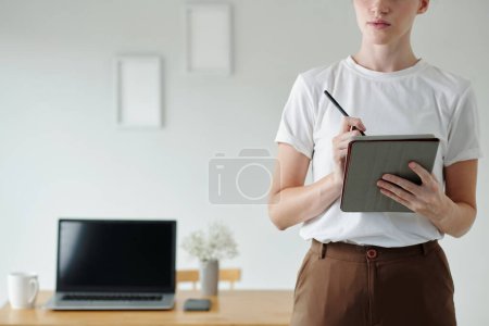 Foto de Imagen recortada del planificador de llenado de mujer joven en la computadora tableta - Imagen libre de derechos