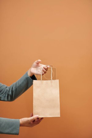 Foto de Manos de la vendedora sosteniendo bolsa de papel con orden - Imagen libre de derechos